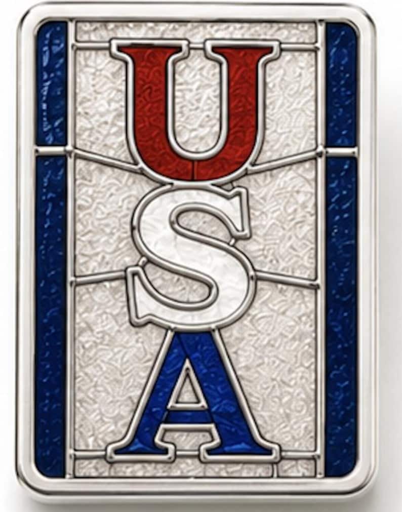 May include: Rectangular metal pin featuring the letters "USA" in red, white, and blue. The letters are designed in a stained glass style, set against a textured background with a silver border. A patriotic design.