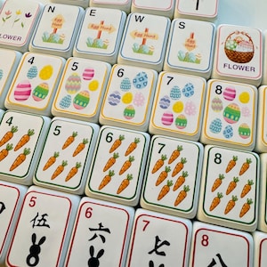 May include: A selection of white tiles with diverse designs, including Easter eggs, carrots, and floral patterns. Some tiles feature the word "JOKER" and "HAPPY EASTER". Other tiles have numbers and Chinese characters.