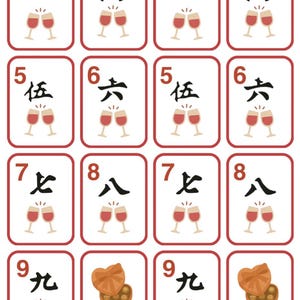 K&ouml;nnte beinhalten: Ein Kartenspiel mit rot-wei&szlig;en R&auml;ndern. Die Karten zeigen Zahlen und chinesische Schriftzeichen, zusammen mit Illustrationen von Sektgl&auml;sern, Pralinen, Geschenkboxen und Amor. Das Wort "JOKER" ist ebenfalls vorhanden.