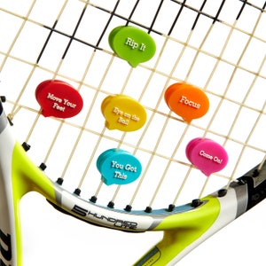 May include: A tennis racket with colorful motivational phrases attached to the strings. The phrases include "Rip It", "Move Your Feet", "Eye on the Ball", "You Got This", "Focus", and "Come On!"