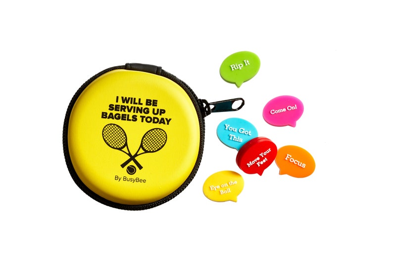 May include: Yellow round case with a zipper and the text "I will be serving up bagels today" with two tennis rackets and a tennis ball. The case comes with six colorful motivational speech bubbles with text such as "Rip It", "You Got This", "Come On", "Move Your Feet", "Focus", and "Eye on the Ball".
