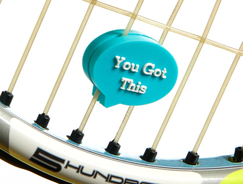 May include: A turquoise blue tennis racket charm with the text "You Got This" in white lettering.