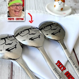 May include: Three stainless steel spoons with a custom engraved face design. The spoons have the text "Stirring up trouble" and "years" engraved on the handles. A photo with the text "PHOTO CUSTOM" is in the upper left corner.