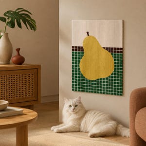 May include: A rectangular sponge cloth featuring a yellow pear graphic centered on a background of white and green grid patterns, separated by a thin dark brown horizontal line, with a textured surface and a ribbed finish.