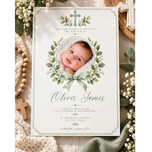 Könnte beinhalten: Eine Taufeinladungskarte mit einem zentralen ovalen Foto eines Babys, umrahmt von grünen Aquarellblättern und einer Schleife. Der Text lautet: You are kindly invited to the baptism of Oliver James, Sunday, April 26, 2026, at 11 o'clock in the morning.