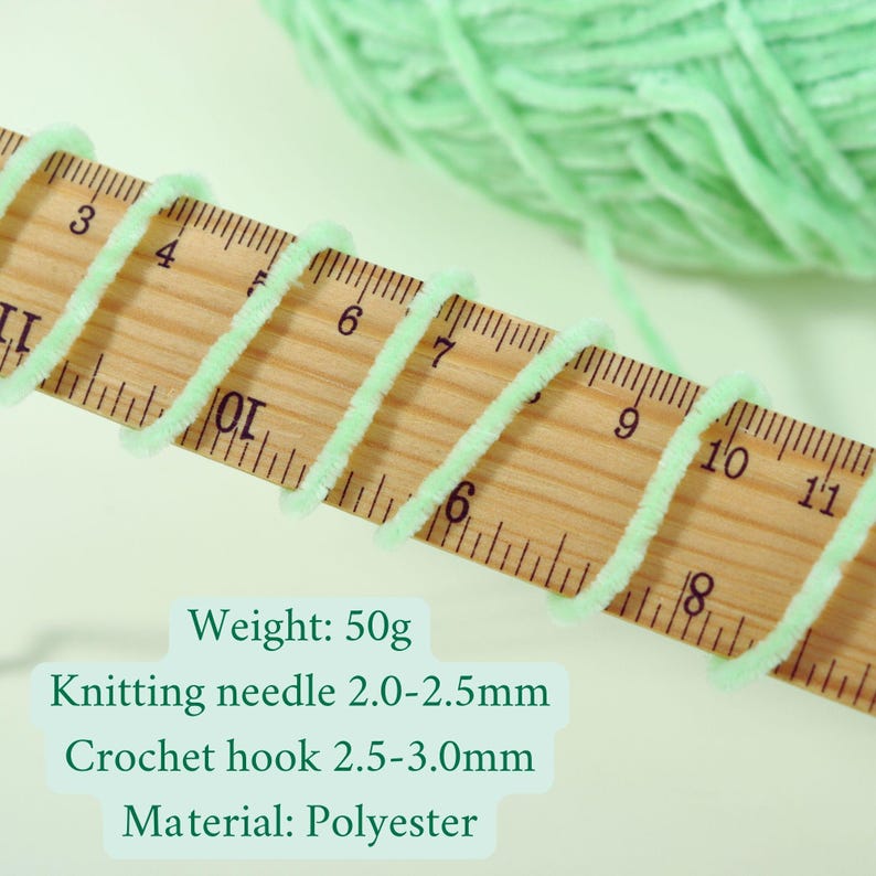 May include: Close-up of light green yarn wrapped around a wooden ruler. The text on the image reads "Weight: 50g, Knitting needle 2.0-2.5mm, Crochet hook 2.5-3.0mm, Material: Polyester". A ball of yarn is in the background.