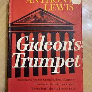 May include: A vintage book cover with the title "Gideon's Trumpet" in large white letters. The cover is predominantly red with black and white graphic elements. The author's name, Anthony Lewis, is in yellow. Text from Attorney General Robert F. Kennedy is also visible.