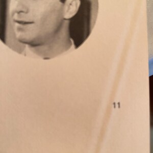 以下が含まれることがあります： 円形のフレームに入った男性の白黒ポートレート。男性は左を見ています。背景は明るいタン色です。数字の11が右下隅に印刷されています。