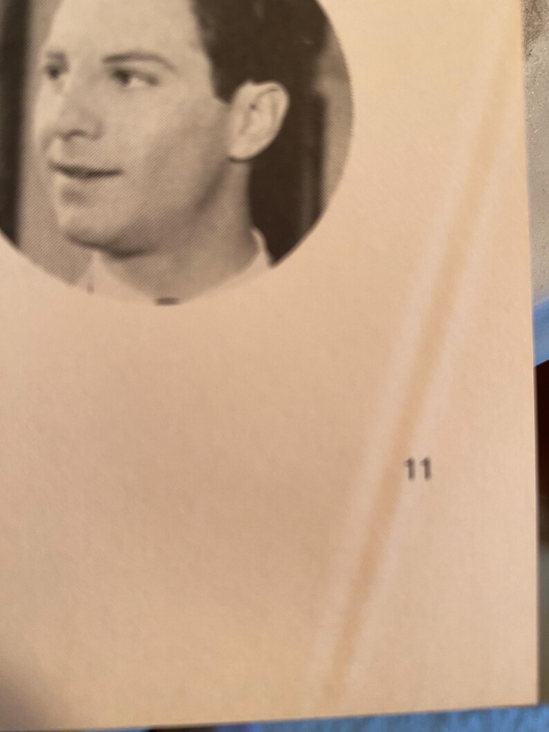 以下が含まれることがあります： 円形のフレームに入った男性の白黒ポートレート。男性は左を見ています。背景は明るいタン色です。数字の11が右下隅に印刷されています。