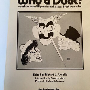 以下が含まれることがあります： 「Why a Duck?」というタイトルの本の表紙。マルクス兄弟の漫画風似顔絵が描かれています。「visual and verbal gems from the Marx Brothers movies」というテキストと、編集者、寄稿者、出版社の名前も含まれています。