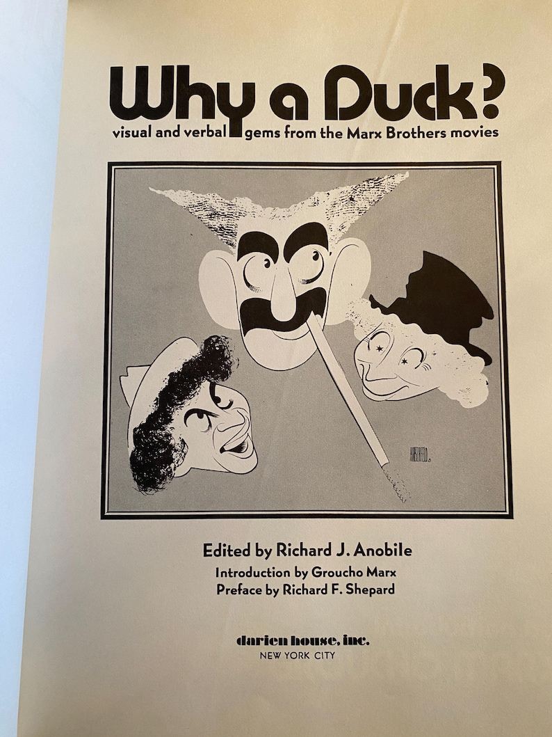 以下が含まれることがあります： 「Why a Duck?」というタイトルの本の表紙。マルクス兄弟の漫画風似顔絵が描かれています。「visual and verbal gems from the Marx Brothers movies」というテキストと、編集者、寄稿者、出版社の名前も含まれています。