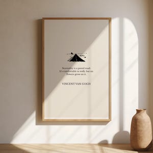 Puede incluir: Una impresión artística enmarcada con una cita de Vincent Van Gogh. La impresión tiene un fondo beige con una ilustración en negro de una carretera. La cita dice: "La normalidad es un camino pavimentado: Es cómodo caminar, pero no crecen flores en él."