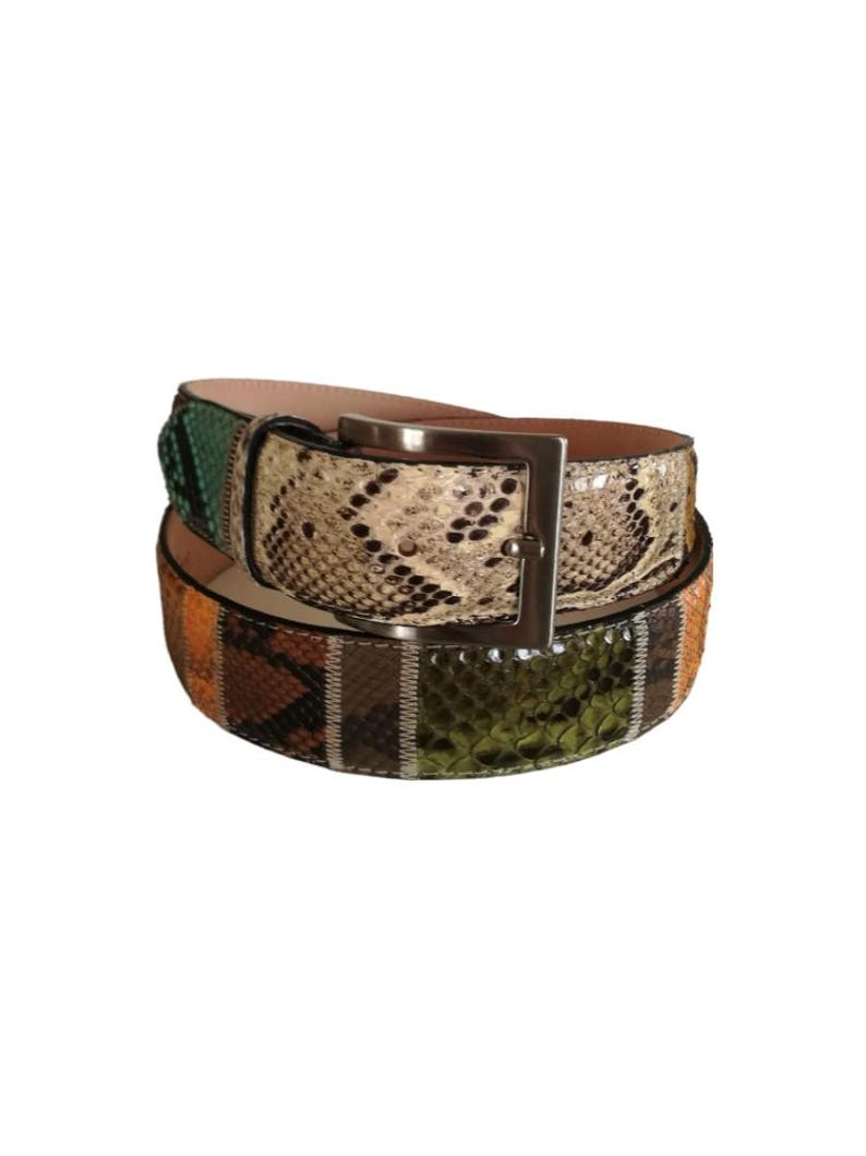 May include: Two leather belts with silver buckles. The top belt has a snakeskin pattern in cream, black, and green. The bottom belt features a snakeskin pattern in orange, brown, and green.