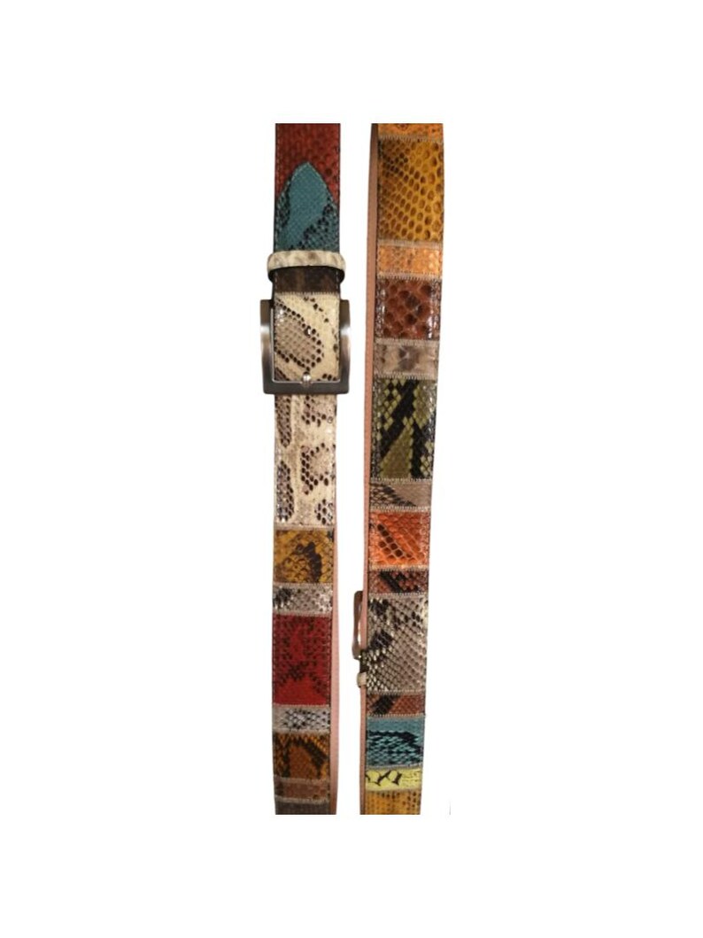 May include: A patchwork belt in various reptile skin patterns. The belt displays a mix of colours including red, blue, yellow, and brown. It has a silver-toned buckle and a leather backing. The belt's design is eye-catching.