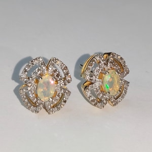 Könnte beinhalten: Eine weiße Keramik-Tasse mit schwarzem Henkel und dem Text "But First, Coffee" in fetter, schwarzer Schrift. Die Tasse steht vor einem verschwommenen Hintergrund, der eine gemütliche Umgebung suggeriert.