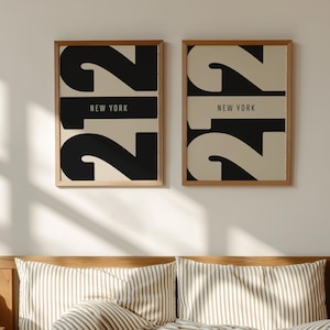 May include: Two framed prints with "212 NEW YORK" in black and beige above a bed with striped bedding. The bed has a wooden headboard and a brown blanket. The room has natural light.
