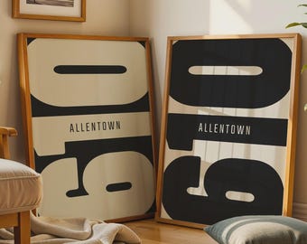 May include: Two framed rectangular wall art prints featuring the large black numbers 610 and the text ALLENTOWN in a sans-serif font. One print has a cream background with black numbers, while the other has a black background with cream numbers.