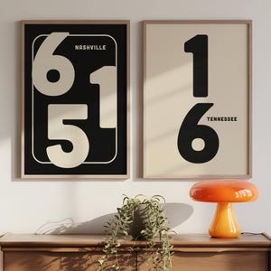 Puede incluir: Dos láminas enmarcadas con un diseño minimalista. Una presenta los números 6, 1 y 5 en color crema sobre un fondo negro, con "Nashville" arriba. La otra lámina muestra los números 1 y 6 en negro sobre un fondo crema, con "Tennessee" debajo.