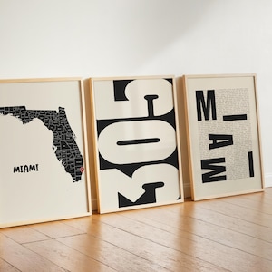 May include: Three framed wall art prints. The first shows a black map of Florida with a red location pin on Miami. The second features large black numbers 305 on a cream background. The third displays the word MIAMI in bold black letters over text.