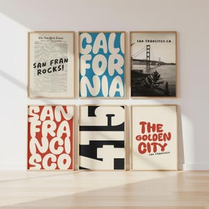 Op de afbeelding: Zes ingelijste kunstprints met een reisthema. De prints bevatten tekst en afbeeldingen gerelateerd aan San Francisco en Californië. Het kleurenpalet omvat rood, blauw, zwart en beige. De tekst bevat "San Fran Rocks!", "California" en "The Golden City".
