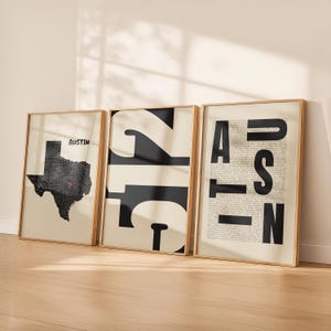 May include: Three framed wall art prints in light wood frames. The left print shows a black map of Texas with a red location marker on Austin. The center print features the large black numbers 512. The right print displays the word AUSTIN in bold.