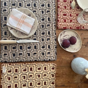 Peut inclure: Ensemble de trois mugs en céramique avec une finition mate et mouchetée. Les tasses sont de couleur crème, gris clair et gris foncé. Chaque mug a un design simple et minimaliste.