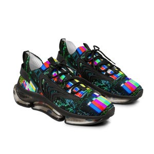 May include: Pair of athletic shoes with a vibrant, colorful design. The shoes feature a black base with a pattern of colorful rectangles and a dark green floral design. The soles are clear with black accents.