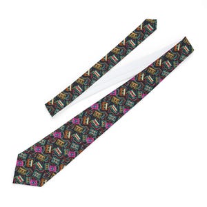 Op de afbeelding: Een zwarte stropdas met een herhaald patroon van kleurrijke cassettes. De cassettes zijn in tinten roze, oranje, groen en geel, met een witte voering aan de achterkant. Een klassiek accessoire.