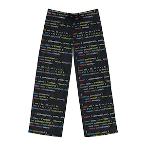 May include: Black pajama pants covered in a repeating pattern of colorful computer code. The code includes text such as "function greet(name)" and "console.log(greet("JavaScript")".