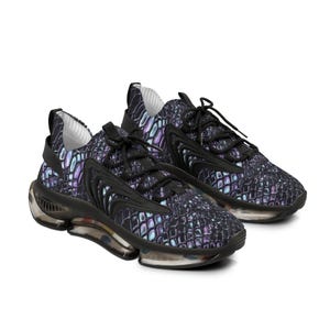 May include: A pair of athletic shoes with a textured, iridescent pattern in shades of purple, blue, and black. The shoes have black laces, accents, and soles with a clear, bubble-like section. The overall design is modern and sporty.
