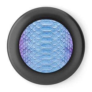 May include: A round, black object with a textured, blue and purple snakeskin pattern in the center. The snakeskin pattern is a gradient of blue and purple. The object has a black, ridged border.
