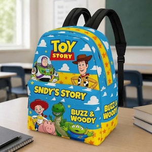 Peut inclure: Un sac à dos bleu avec des personnages de Toy Story, dont Buzz l'Éclair, Woody, Jessie, Rex, Bayonne et un alien. Le sac présente des motifs d'étoiles jaunes, des bretelles noires et le texte Toy Story, Sndy's Story et Buzz & Woody.