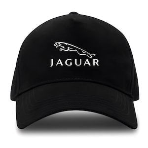 Pode incluir: Boné de beisebol preto com o logotipo Jaguar em branco. O logotipo apresenta um jaguar saltando acima do nome da marca. O boné tem uma aba curva e uma coroa estruturada.
