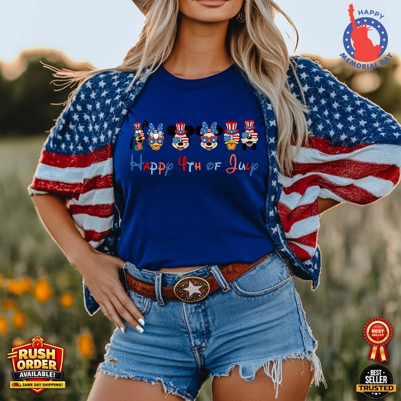Puede incluir: Una camiseta azul con el texto "Happy 4th of July" y personajes de dibujos animados con atuendo patri&oacute;tico. La persona lleva una chaqueta con un dise&ntilde;o de bandera estadounidense roja, blanca y azul. La imagen tambi&eacute;n incluye un cintur&oacute;n marr&oacute;n con una hebilla en forma de estrella.