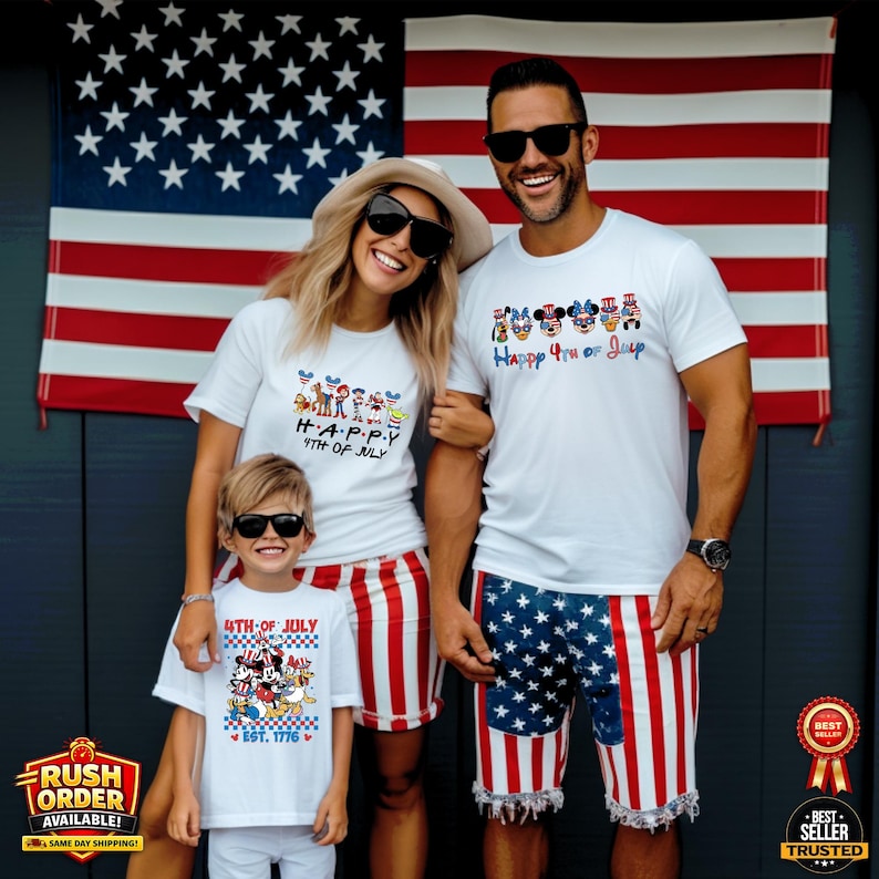 Puede incluir: Familia vestida con camisetas blancas a juego y pantalones cortos patri&oacute;ticos frente a una bandera estadounidense. Las camisetas tienen gr&aacute;ficos coloridos y el texto "Happy 4th of July" y "4th of July EST. 1776". Los pantalones cortos presentan rayas rojas y blancas y un patr&oacute;n de estrellas azules.