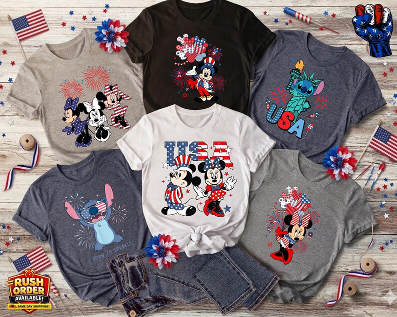 Puede incluir: Colecci&oacute;n de camisetas gr&aacute;ficas patri&oacute;ticas con personajes de Disney. Los dise&ntilde;os incluyen a Mickey y Minnie Mouse en rojo, blanco y azul, Stitch con la Estatua de la Libertad y fuegos artificiales. Banderas americanas y elementos decorativos.