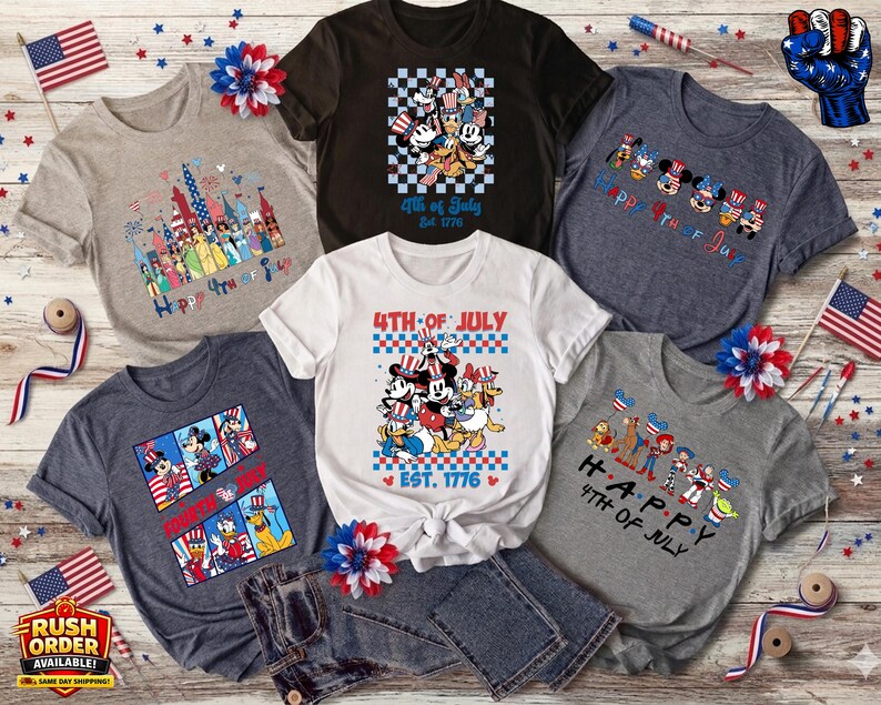 Puede incluir: Colecci&oacute;n de camisetas gr&aacute;ficas con temas patri&oacute;ticos. Los dise&ntilde;os incluyen personajes de Disney, fuegos artificiales y los textos "4th of July" y "Happy 4th of July". Las camisetas son de varios colores, incluyendo gris, blanco y azul marino.