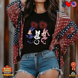 Puede incluir: Camiseta negra con tres personajes de dibujos animados con trajes patri&oacute;ticos y fuegos artificiales. La persona lleva una chaqueta estampada con estrellas y pantalones cortos de mezclilla. La imagen tiene un tema patri&oacute;tico.