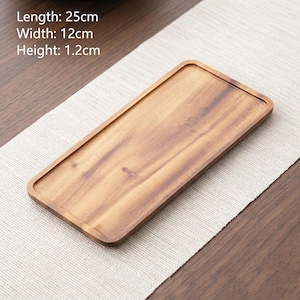 May include: A rectangular wooden tray with a natural brown wood grain finish. The tray features rounded corners and a shallow rim. Text printed on the image indicates dimensions of 25cm in length, 12cm in width, and 1.2cm in height.
