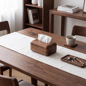 May include: A rectangular dark brown wooden tissue box holder with rounded edges, containing a white tissue. The box is crafted from solid wood with a visible grain pattern, featuring a central slot on the top surface for dispensing tissues.