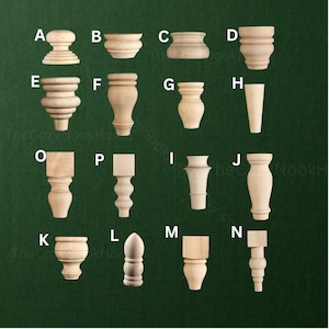 May include: A collection of fourteen unfinished light-coloured wooden furniture feet and legs, labelled A through P, featuring various turned, tapered, and square-topped designs. Each piece is displayed individually against a dark green background.