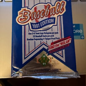 May include: A sealed 1991 Upper Deck Major League Baseball trading card pack. The pack is blue with white and red accents, featuring the word "Baseball" in a stylized font. Text includes "1991 Edition" and "The Collector's Choice."