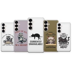May include: A selection of phone cases with amusing designs. One case shows a raccoon baking, another a dancing raccoon, a black cat, a grumpy cat, and two cats. Each case has a unique quote.