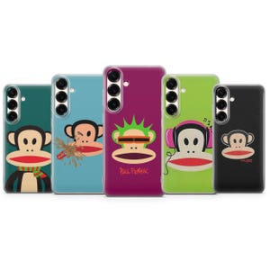 Puede incluir: Cinco fundas para smartphone con el personaje del mono Paul Frank. Las fundas son verde oscuro con bufanda, azul claro con salpicadura de refresco, magenta con cresta verde y gafas naranjas, verde lima con auriculares rosas y negra con logo.