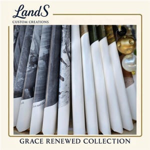 Puede incluir: Una disposici&oacute;n de elementos decorativos blancos y estampados, posiblemente velas o impresiones enrolladas, con el texto "Grace Renewed Collection". Los elementos est&aacute;n dispuestos en forma de abanico, algunos con im&aacute;genes en blanco y negro. La esquina superior izquierda muestra el logotipo "LandS Custom Creations."