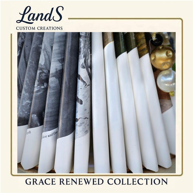 Puede incluir: Una disposici&oacute;n de elementos decorativos blancos y estampados, posiblemente velas o impresiones enrolladas, con el texto "Grace Renewed Collection". Los elementos est&aacute;n dispuestos en forma de abanico, algunos con im&aacute;genes en blanco y negro. La esquina superior izquierda muestra el logotipo "LandS Custom Creations."