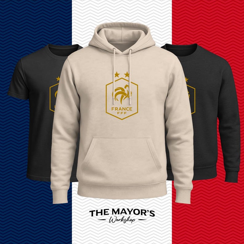 Puede incluir: Una sudadera con capucha de color beige que presenta un emblema hexagonal dorado con un gallo, dos estrellas y el texto FRANCE FFF. A los lados de la sudadera hay dos camisetas negras, una de manga corta y otra de manga larga, con el mismo logo.