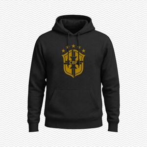 May include: A black hooded sweatshirt featuring a gold-colored graphic on the chest. The design displays a shield emblem with the letters CBF in the center, topped by five small stars arranged in an arc. The hoodie includes a front kangaroo pocket.