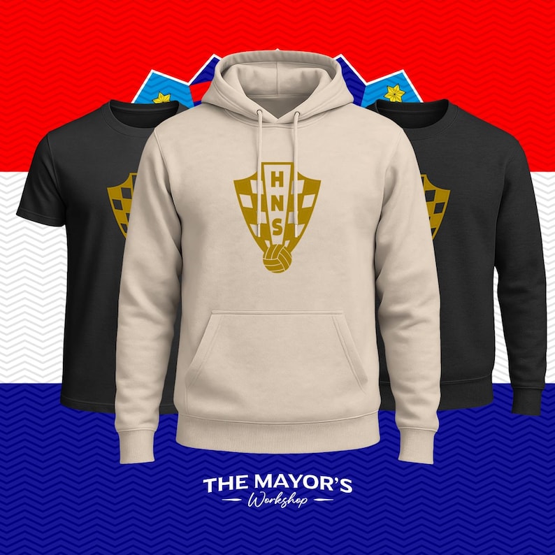 May include: A beige hooded sweatshirt featuring a gold HNS shield logo with a soccer ball at the base, flanked by two black shirts, each displaying the same gold HNS shield logo. The text THE MAYOR'S Workshop is printed in white at the bottom.
