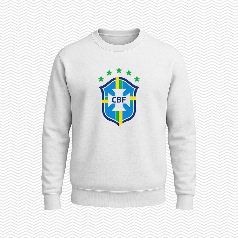 May include: A white long-sleeve crewneck sweatshirt featuring the blue, green, and yellow CBF crest logo centered on the chest. The logo includes a shield shape with a cross, vertical stripes, and five green stars arranged in an arc above it.